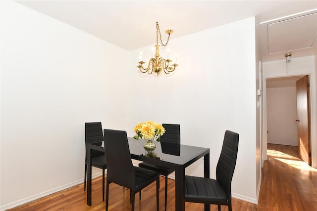 dining area featuring wood-type flooring and a chandelier