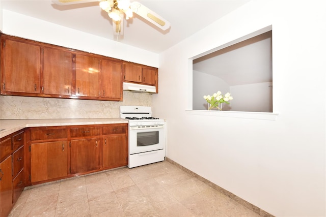 kitchen featuring tasteful backsplash, white range with gas stovetop, and ceiling fan