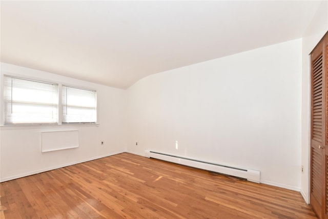 spare room with a baseboard radiator, wood-type flooring, and lofted ceiling