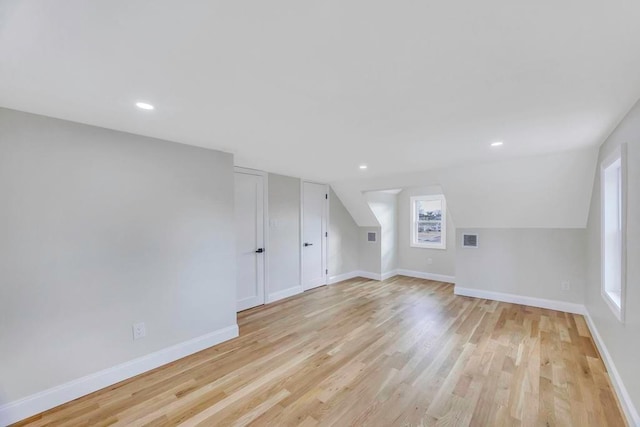 bonus room featuring lofted ceiling and light wood-type flooring