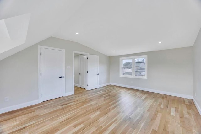 additional living space featuring light hardwood / wood-style flooring and vaulted ceiling