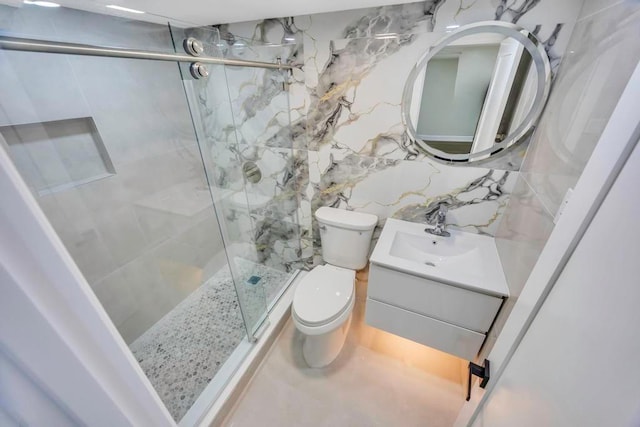 bathroom with tile walls, vanity, decorative backsplash, a shower with shower door, and toilet