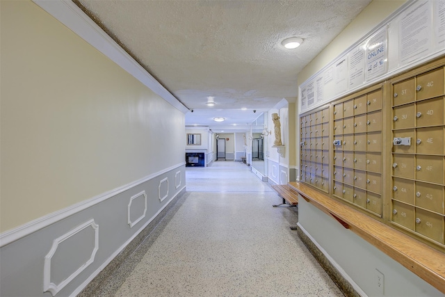 corridor with mail boxes and a textured ceiling