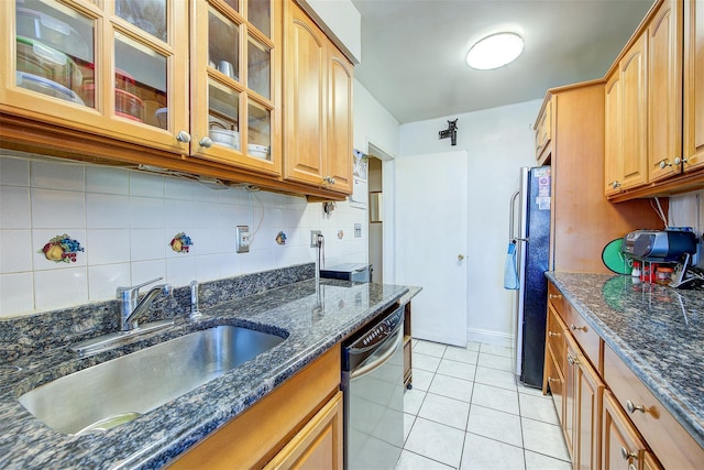 kitchen with light tile patterned flooring, appliances with stainless steel finishes, sink, and dark stone countertops