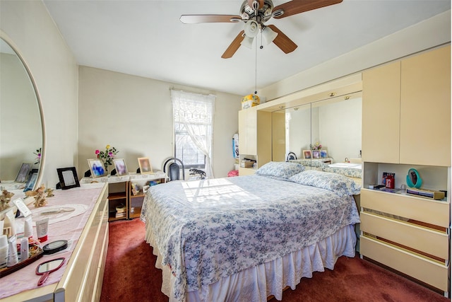 bedroom featuring ceiling fan and dark carpet