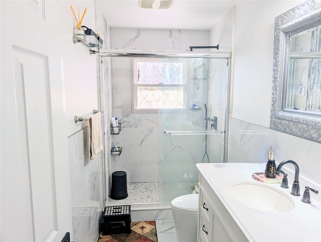 full bathroom featuring toilet, vanity, tile walls, marble finish floor, and a marble finish shower