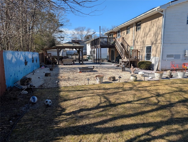 exterior space with stairs, a gazebo, a deck, and fence