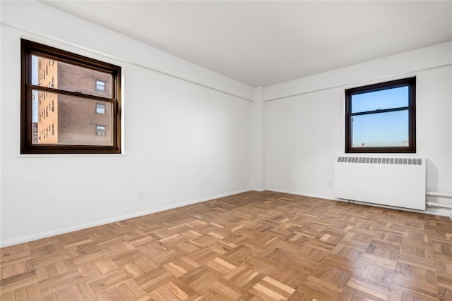 spare room with light parquet flooring and radiator heating unit