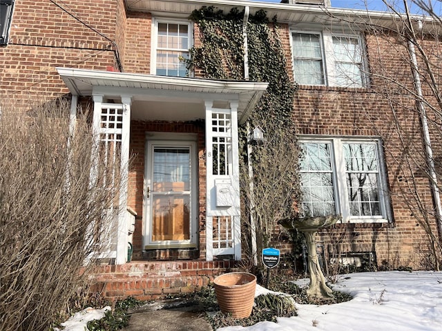 view of exterior entry with brick siding