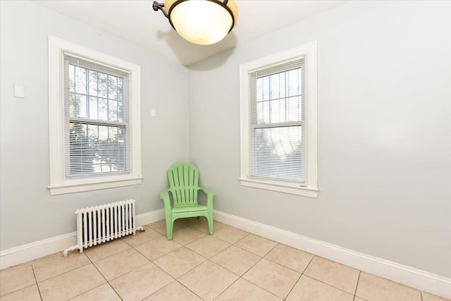 unfurnished room featuring light tile patterned floors and radiator heating unit