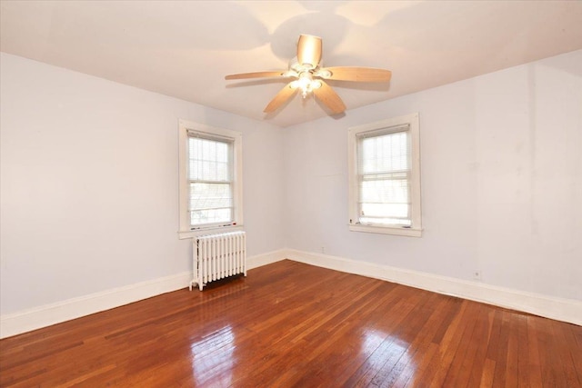 spare room with radiator, plenty of natural light, hardwood / wood-style floors, and ceiling fan