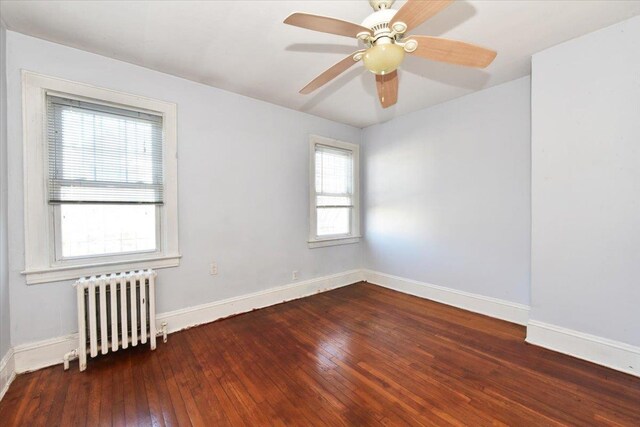 unfurnished room featuring radiator heating unit, dark hardwood / wood-style floors, and ceiling fan