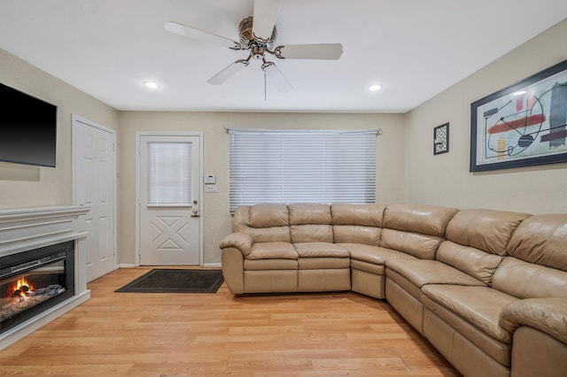 living room featuring light hardwood / wood-style floors and ceiling fan