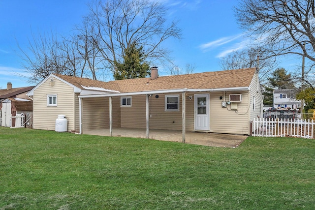 rear view of property with a yard, a shed, a wall unit AC, and a patio area