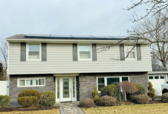 view of front facade featuring a garage and solar panels