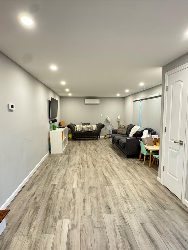 living room with light wood-type flooring and a wall unit AC