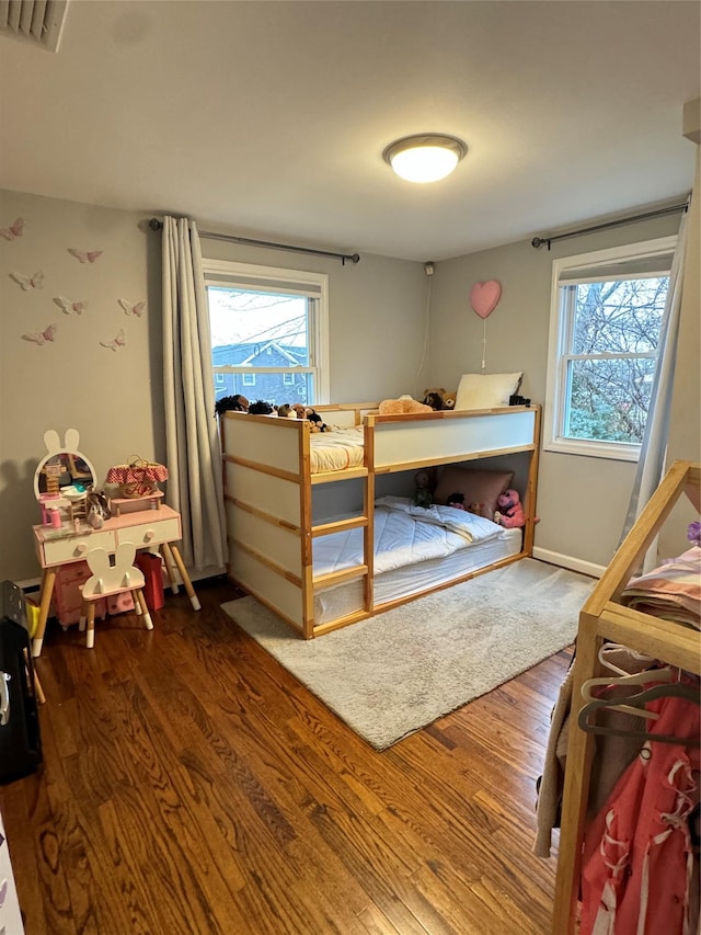 bedroom featuring multiple windows and hardwood / wood-style flooring