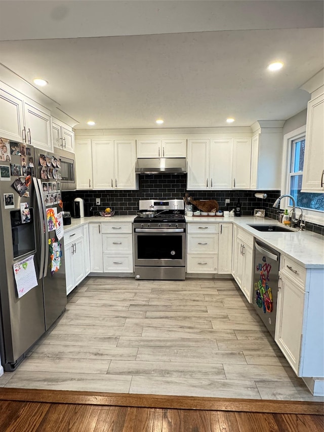 kitchen with white cabinetry, appliances with stainless steel finishes, sink, and light hardwood / wood-style flooring