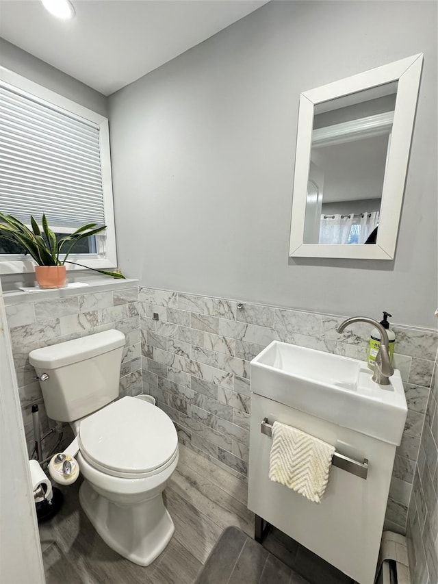 bathroom featuring tile walls, vanity, hardwood / wood-style flooring, and toilet