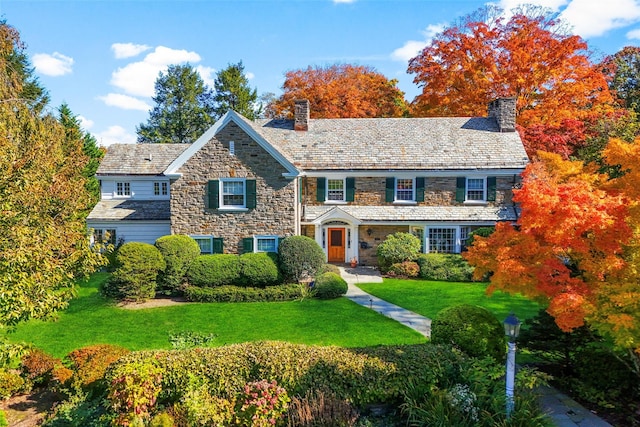 colonial inspired home featuring a front lawn