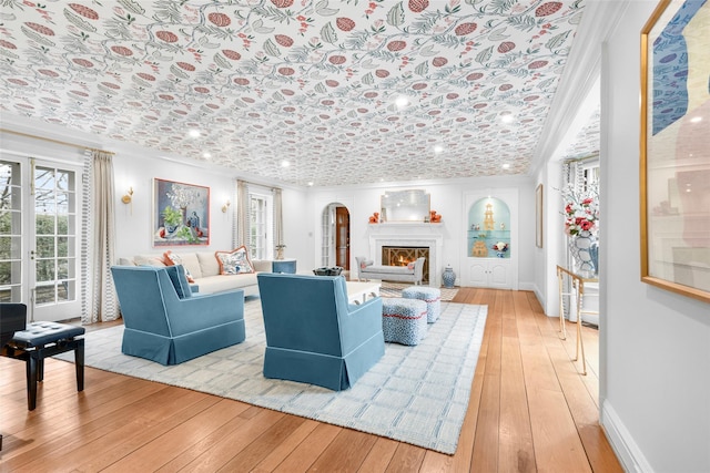 living room with ornamental molding and light hardwood / wood-style flooring