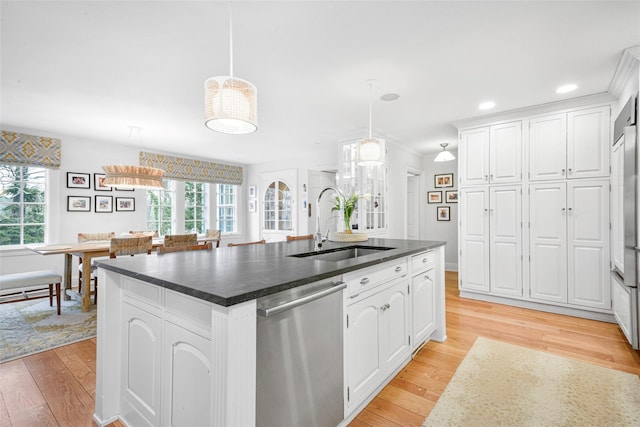 kitchen with white cabinetry, stainless steel dishwasher, a kitchen island with sink, and pendant lighting