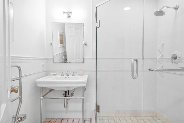 bathroom featuring sink, tile walls, and an enclosed shower