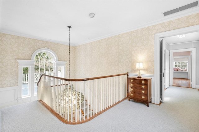 hallway featuring ornamental molding, light carpet, and a chandelier