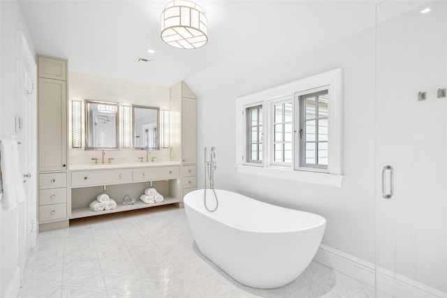 bathroom featuring vanity, a tub to relax in, and vaulted ceiling