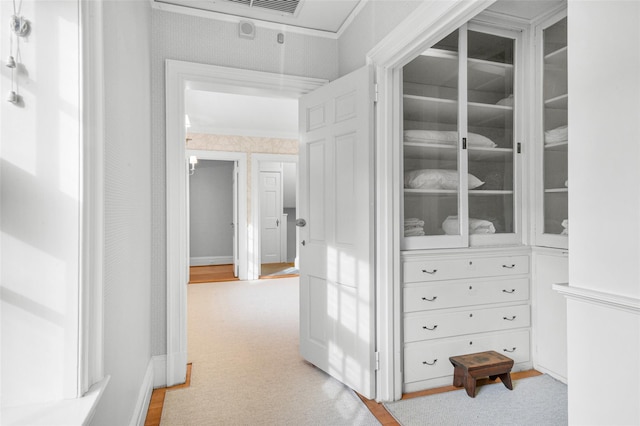 hall featuring light carpet and crown molding