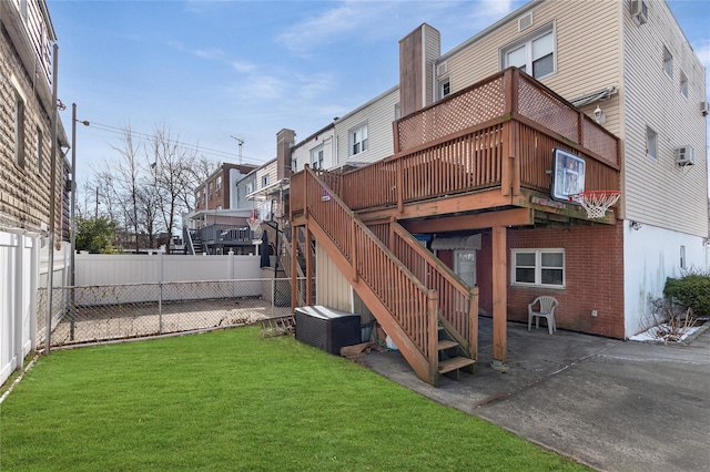 back of property featuring a wooden deck, a lawn, and a patio