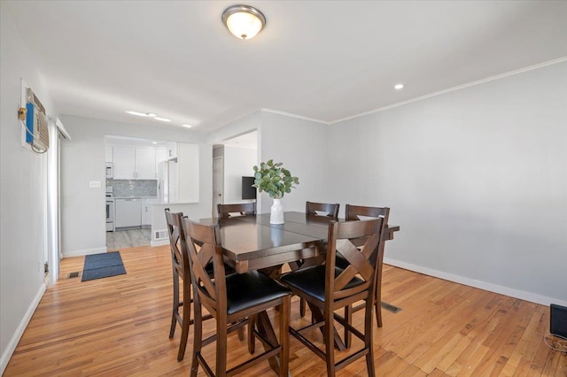 dining room featuring crown molding and light hardwood / wood-style floors