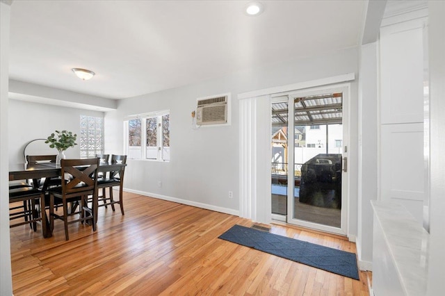 dining area with hardwood / wood-style floors and a wall mounted AC