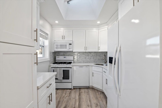 kitchen featuring sink, white cabinets, white appliances, and light hardwood / wood-style floors