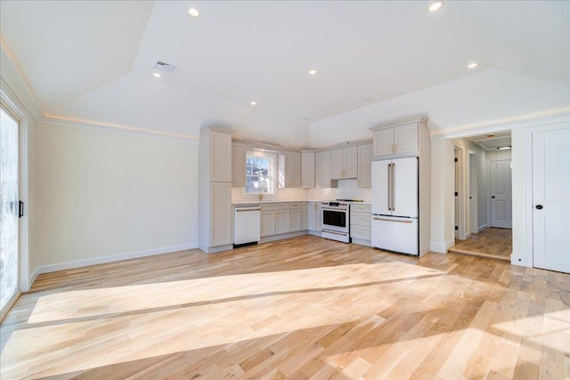 kitchen featuring white appliances, vaulted ceiling, and light wood-type flooring