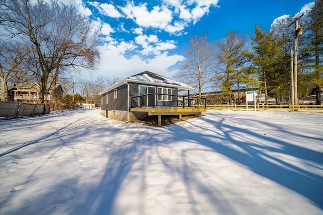 snow covered rear of property featuring a deck