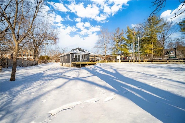 yard layered in snow with a sunroom