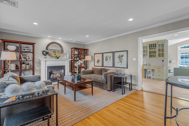 living room with ornamental molding and light hardwood / wood-style flooring