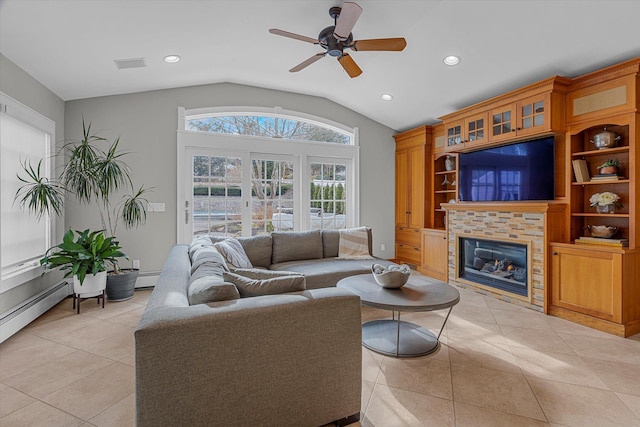 living room featuring lofted ceiling, light tile patterned floors, ceiling fan, a baseboard heating unit, and a stone fireplace