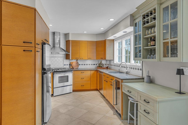 kitchen with appliances with stainless steel finishes, sink, wine cooler, light tile patterned floors, and wall chimney exhaust hood