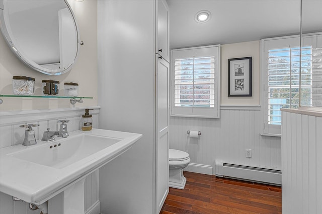 bathroom with hardwood / wood-style flooring, plenty of natural light, toilet, and baseboard heating