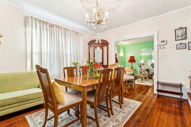 dining room featuring dark hardwood / wood-style flooring, crown molding, and a chandelier