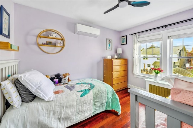 bedroom featuring dark wood-type flooring, a wall mounted air conditioner, and ceiling fan