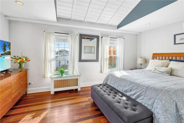 bedroom with radiator, vaulted ceiling, and dark hardwood / wood-style floors