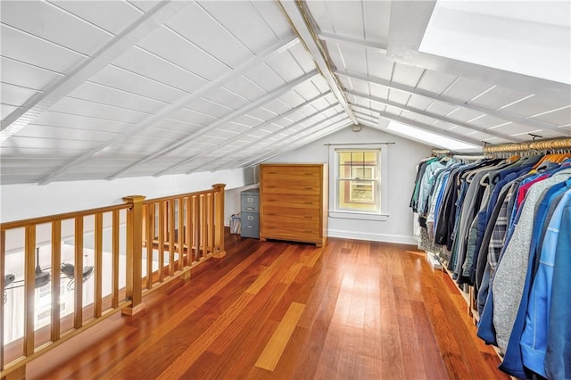 walk in closet featuring hardwood / wood-style flooring and vaulted ceiling