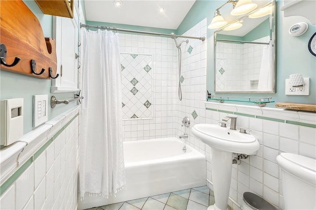 bathroom with tile walls, shower / tub combo, tile patterned floors, and toilet