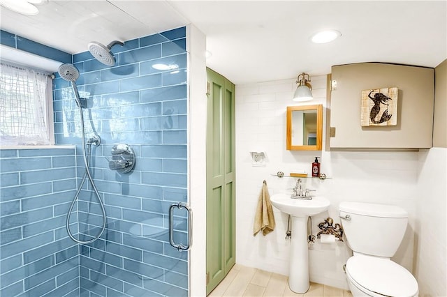 bathroom featuring tile patterned floors, a shower with door, and toilet