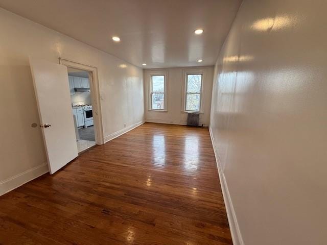 unfurnished room with dark wood-type flooring and radiator