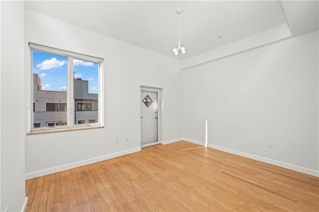 empty room featuring baseboards and light wood finished floors