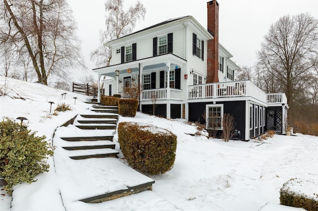 view of front of house with a chimney and a wooden deck